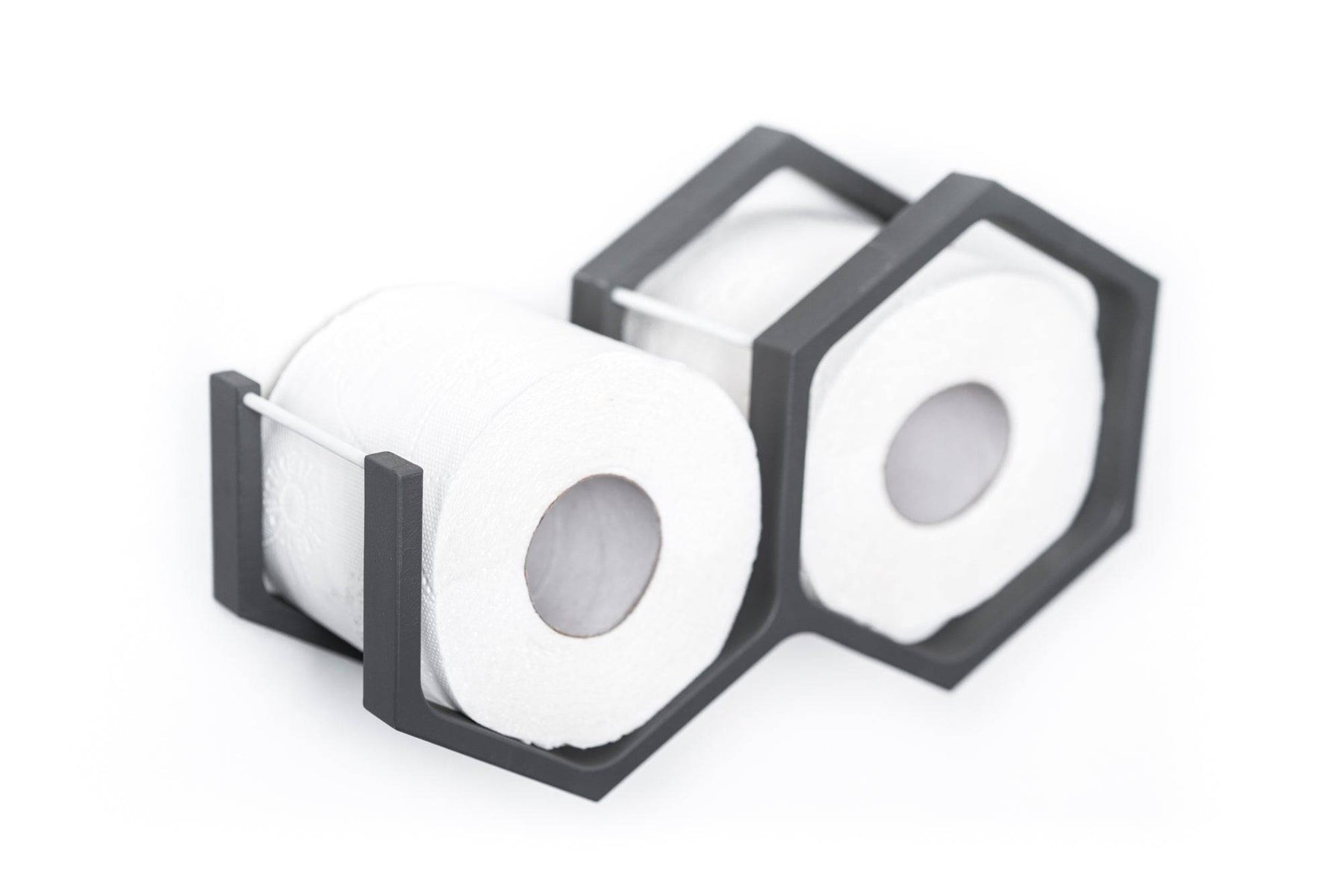 Close-up of a wall-mounted gray mini honeycomb toilet paper holder, displaying two rolls of toilet paper. The holder features a textured wood surface, highlighting the natural grain in a modern design.