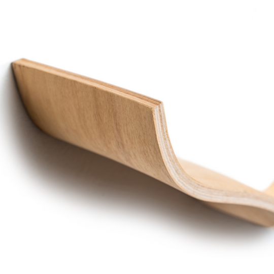 Close-up of an ash wooden shelf with a smooth, cloud-like, curved edge, showing the refined, natural wood grain and texture.